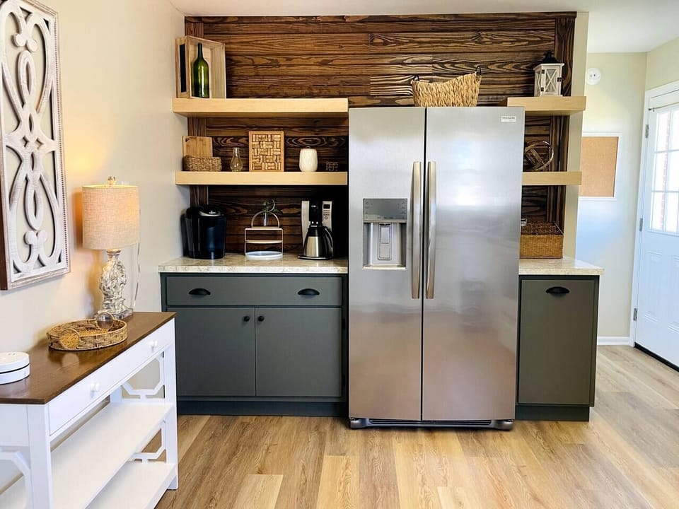 A brand new refrigerator with in-door ice and water dispenser. The door to the left goes out to the back deck. Coffee options include both a keurig and a 12-cup drip coffee pot.