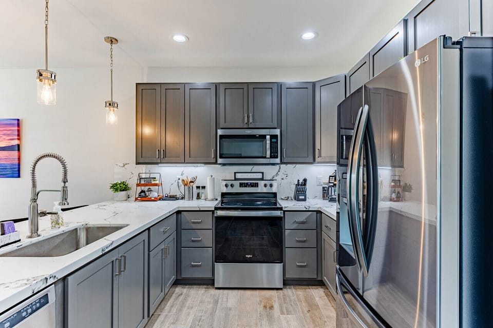 Spacious, modern kitchen with stainless steel appliances, quartz countertops, and a convenient island.
