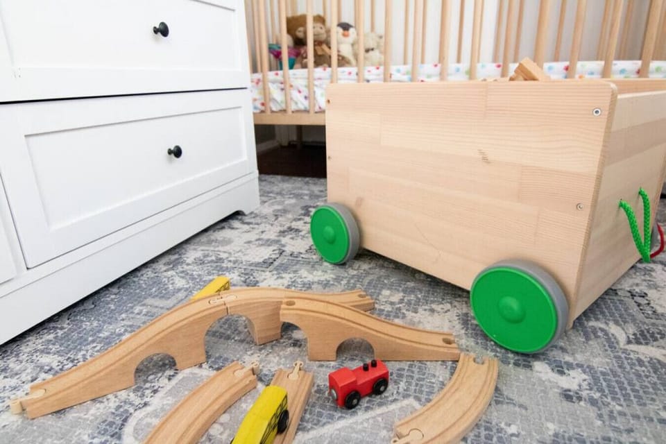Cot in the sunroom of the living room with toys