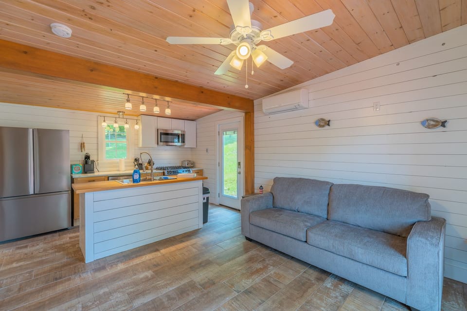 Open-concept living area with modern kitchen, cozy seating, and natural wood accents