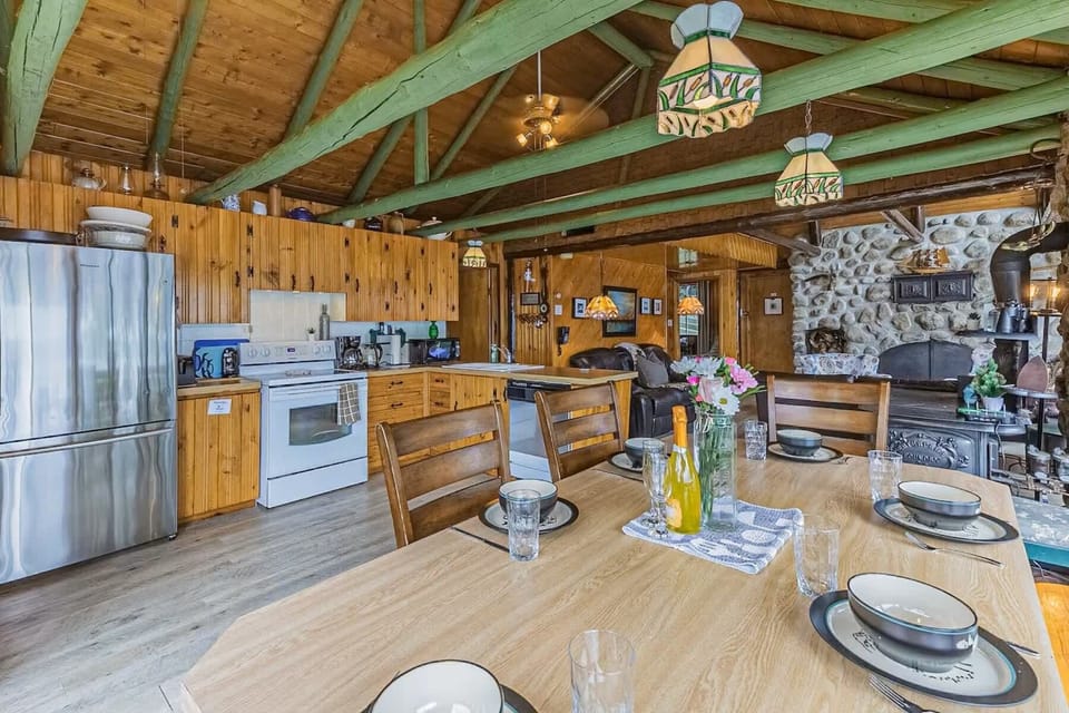 Dining table set for guests in a cabin kitchen with rustic charm