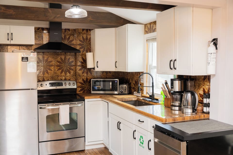 Fully stocked kitchen with a dishwasher, oven, toaster, coffee maker, microwave