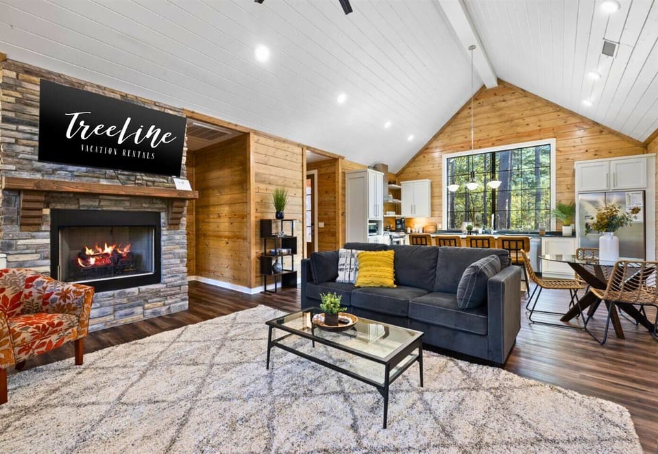 Sink into comfort by the fireplace, your living room framed by nature.