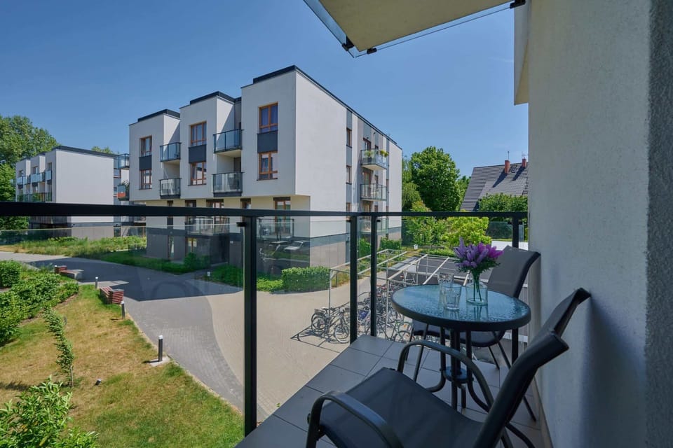 A cozy balcony equipped with chairs, offering a peaceful view of green surroundings.