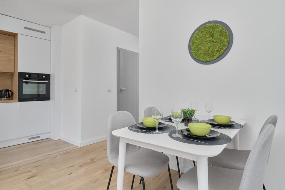 A spacious layout combining a stylish living room and a dining area with a large window for natural light.