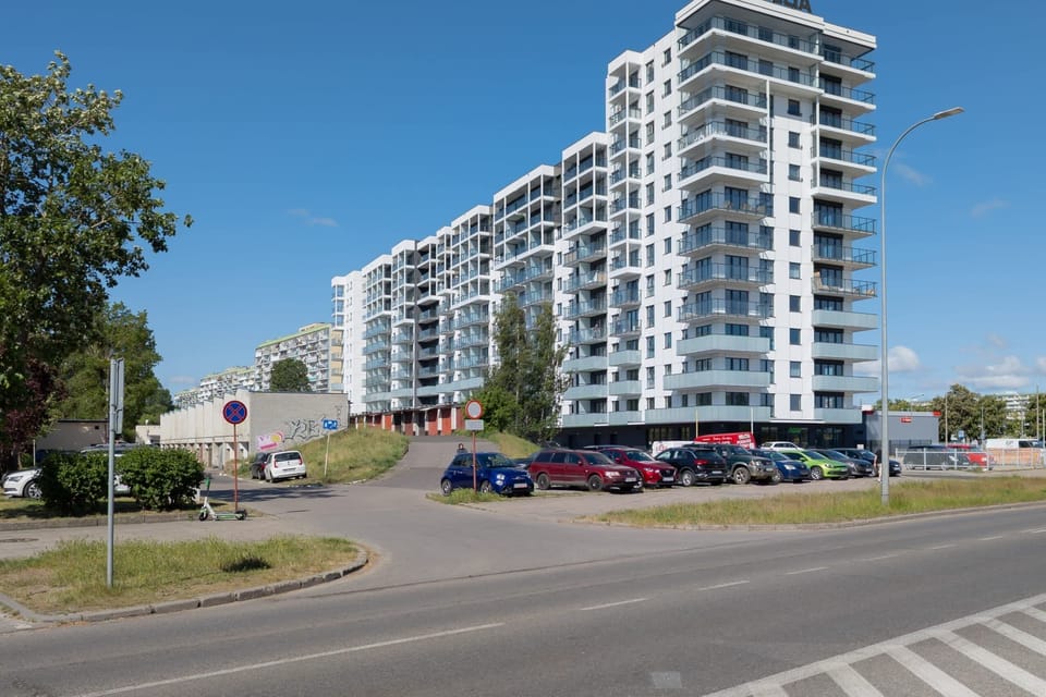 A photo of the apartment building's modern design, surrounded by greenery and a clean urban environment.