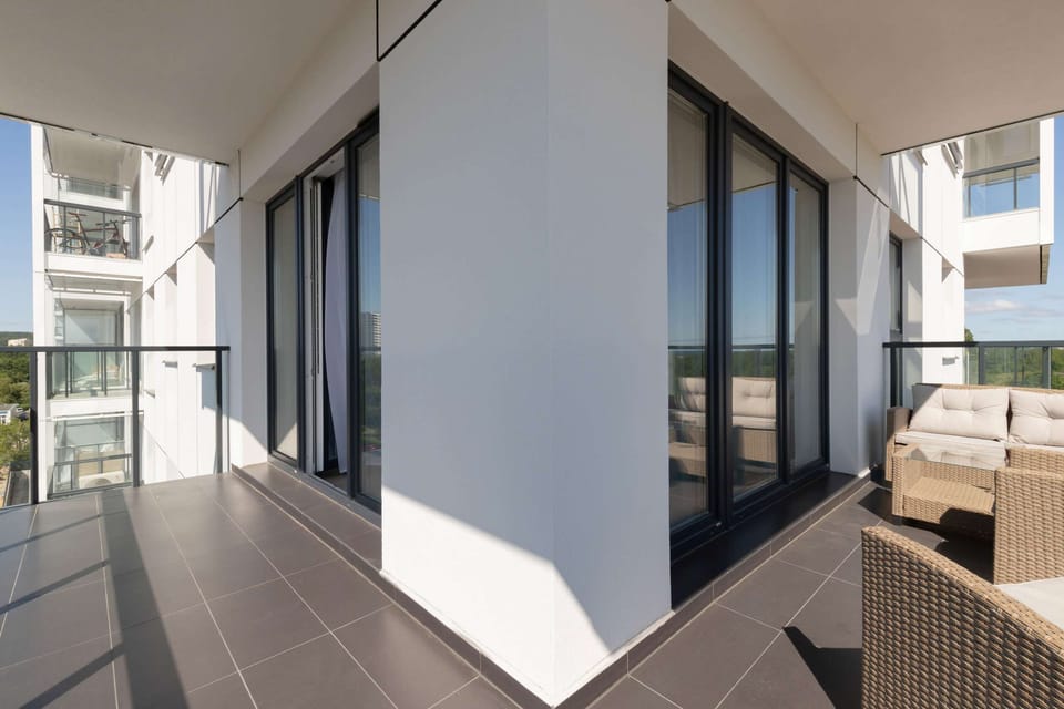 A spacious balcony equipped with outdoor furniture, offering a perfect spot to enjoy the view.