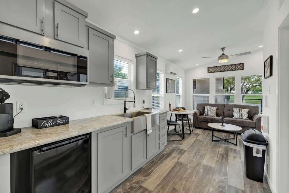 The cozy kitchenette features a compact ensemble: a mini fridge, microwave, and coffee pot, perfect for quick and convenient culinary moments.