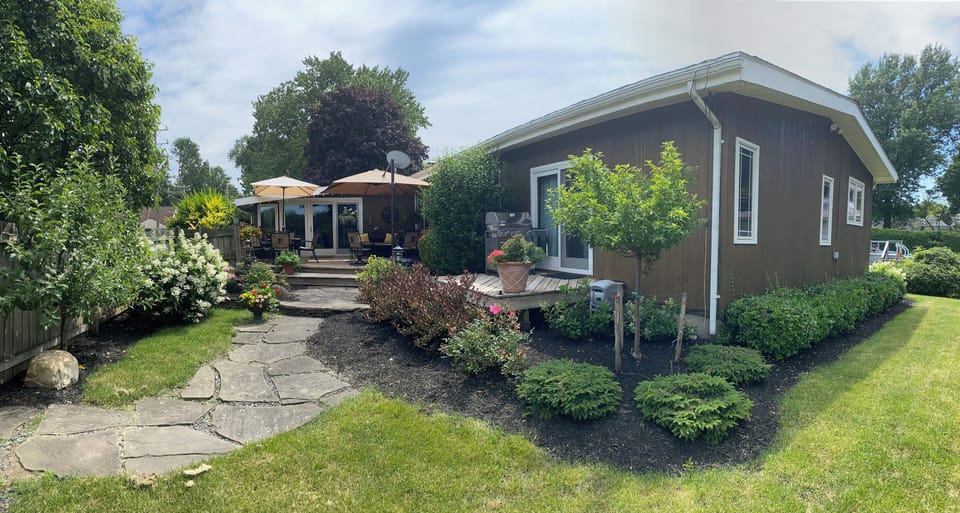 Fenced in back yard with seasonally furnished wood deck. 