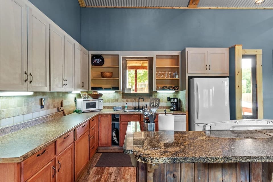 The large, full kitchen has a fridge/freezer, stove/oven, microwave, coffee maker, dishes & utensils, and pots & pans. 