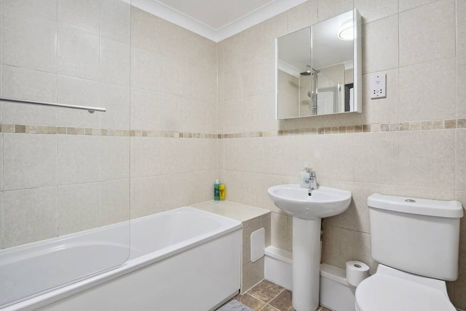 this modern bathroom is designed with a bathtub and toilet, each separated by a sleek glass divider.