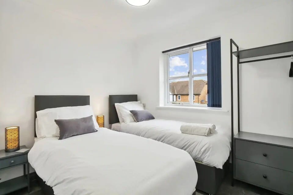 The room is furnished with two single-size beds with zip and link options, each providing a comfortable sleeping space for two person.