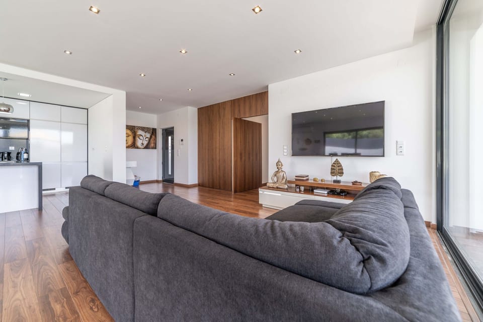 Modern open-plan living room with grey corner sofa — Villa Bahia, luxury holiday villa in Sesimbra