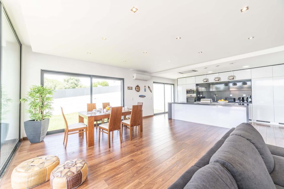 Bright open-plan living space with wooden dining table — Villa Bahia, luxury holiday villa in Sesimbra