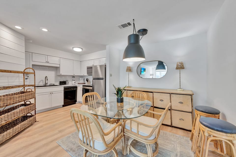 Your modern kitchen flows seamlessly into a bright dining space with warm wood accents and stylish pendant lighting.
