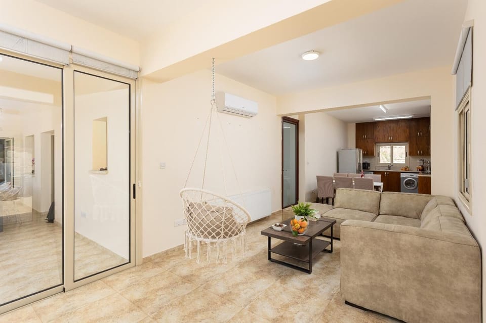 Open-plan living room with sofa, dining area, kitchen, A/C, WiFi internet, satellite TV, and terrace access