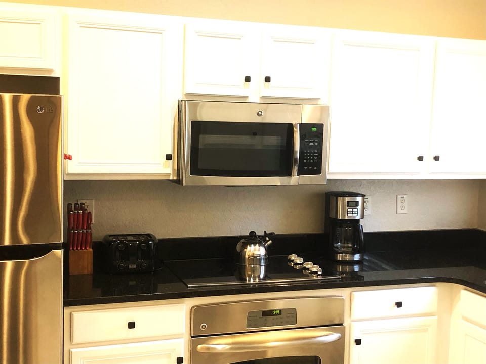 Fully equipped kitchen with stainless appliances and solid surface countertops