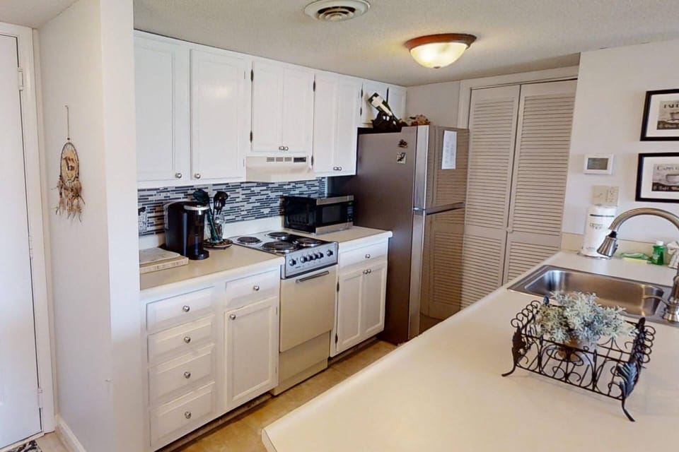 The galley kitchen offers plenty of storage and additional seating at the island!