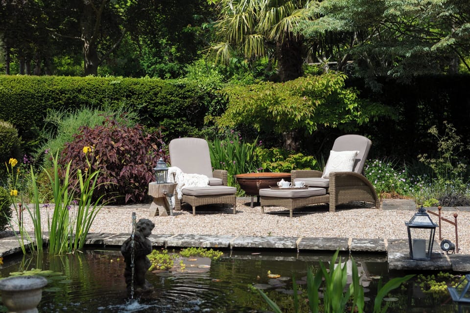 Garden with two sun loungers and pond 