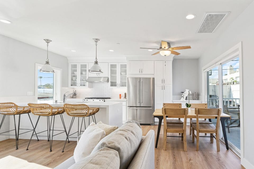 Kitchen with brand new appliances, 4 seater dining table and 3 high top bar stools at the eat in counter