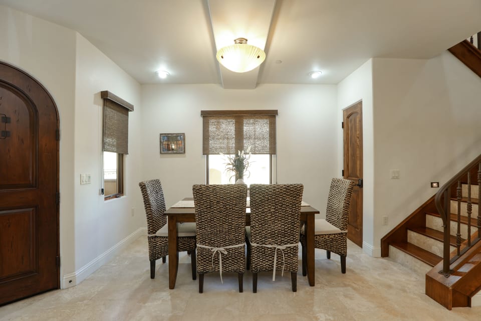 Seating for six at the dining table, with additional bar stools at the kitchen counter.