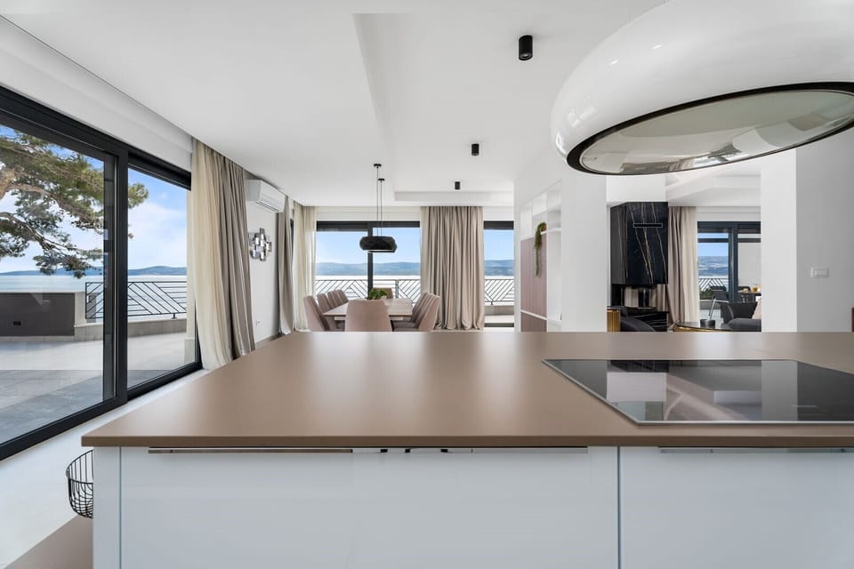 Fully equipped kitchen with an island and luxuriously decorated dining room with a magical view of the crystal blue sea