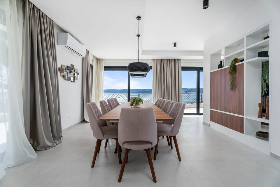 Fully equipped kitchen with an island and luxuriously decorated dining room with a magical view of the crystal blue sea