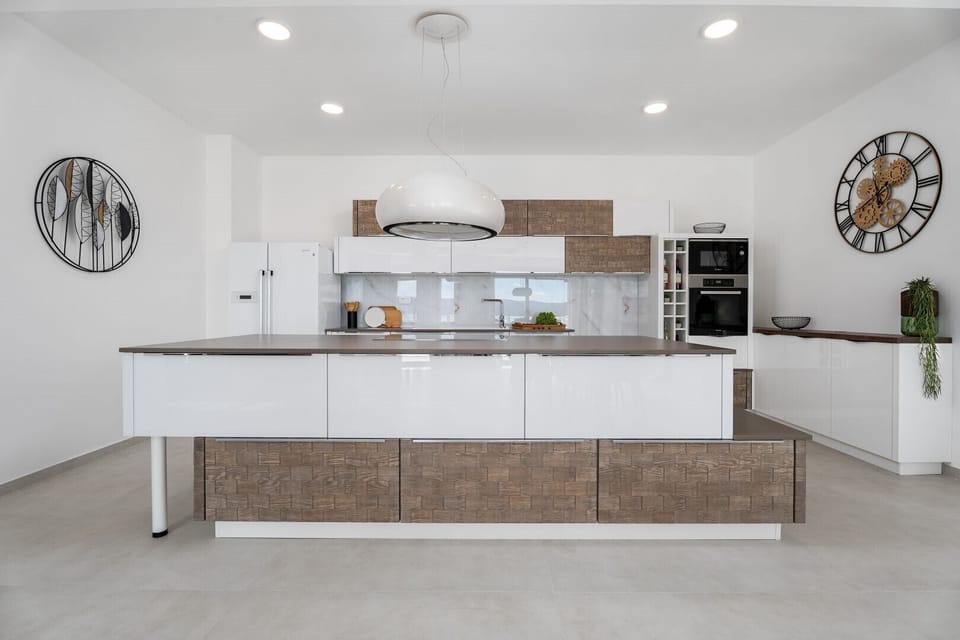 Fully equipped kitchen with an island and luxuriously decorated dining room with a magical view of the crystal blue sea