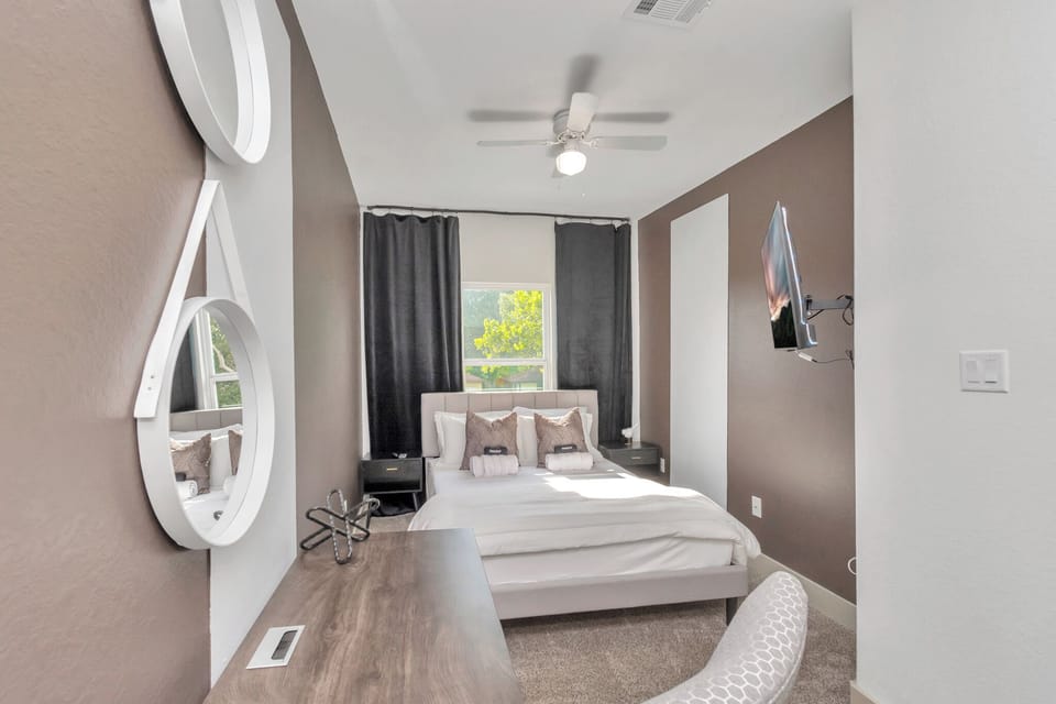 Unit A Upstairs bedroom 2 with queen size bed, 55 inch TV, 2 bedside table and a workstation