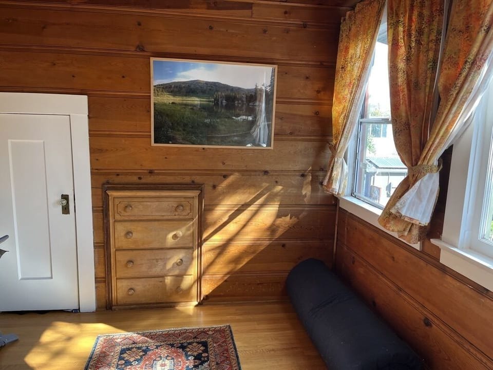Bedroom 3 has a Toshiba TV and a Japanese futon. Wood paneling and garden views
