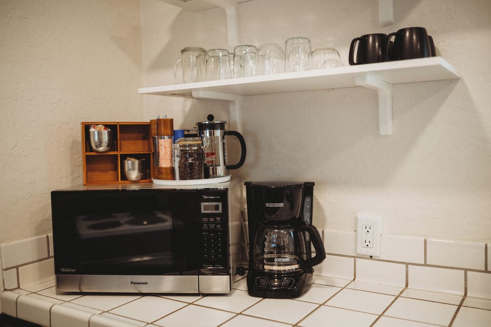 Your morning essentials—coffee, mugs, and a microwave at the ready.
