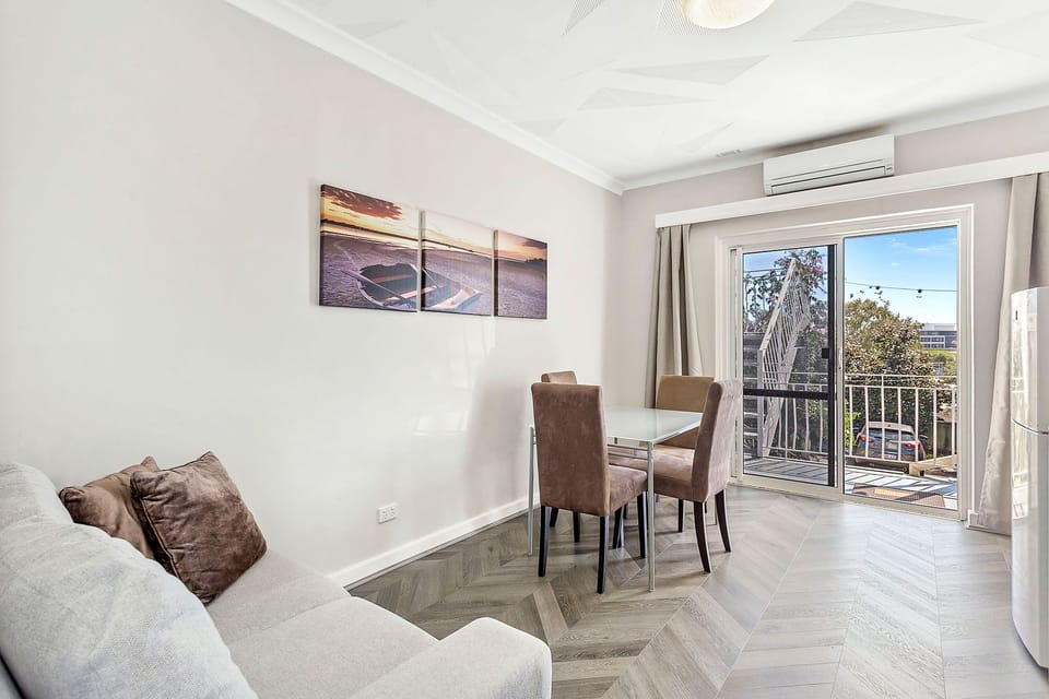 Comfortable and airy living space with natural light and a dining area for four.