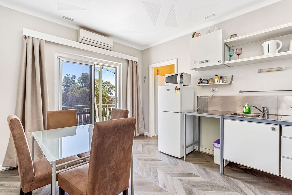 Imagine enjoying a meal at this inviting dining table, surrounded by natural light and views of the outdoors.
