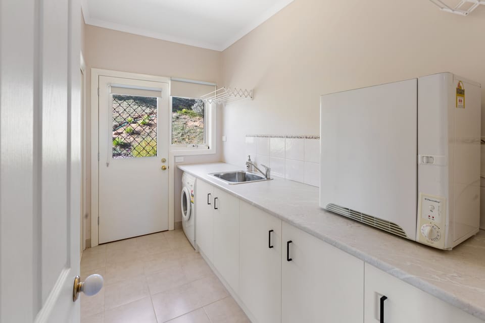 Laundry with washing machine, dryer and hanging space. 
