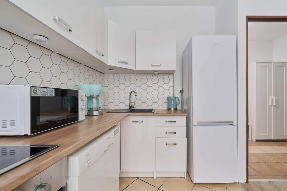 Kitchenette with plenty of kitchen utensils and dishes. 