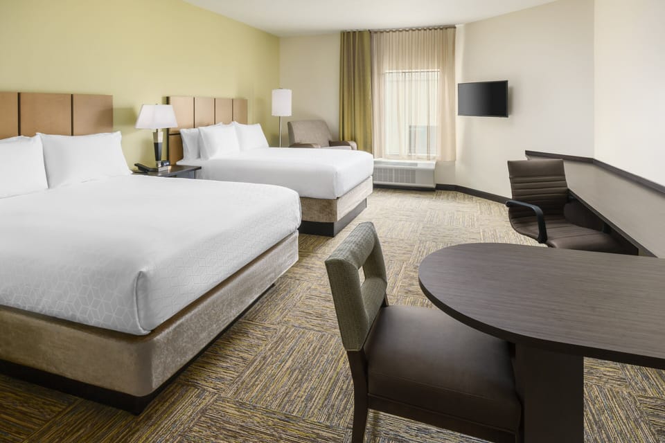 Unwind in a spacious double-queen room with cozy workspace.