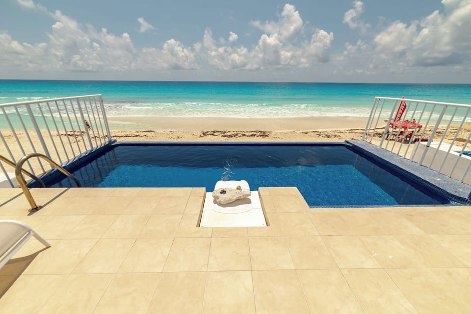Your private infinity-edge pool melting into the Caribbean Sea”