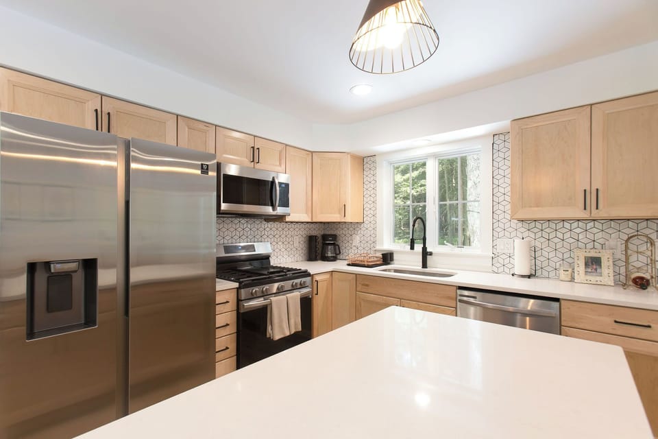 Crisp and clean kitchen with all the necessary utensils, dishes, & cookware