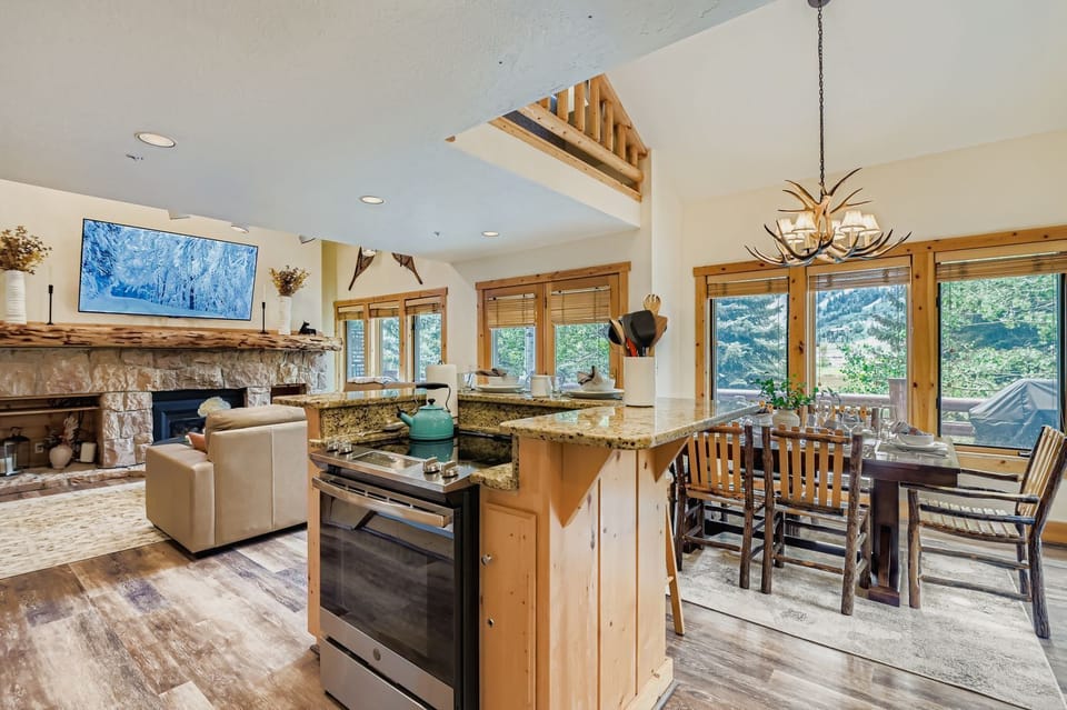 Enjoy this open-concept living area with a fully equipped kitchen and rustic dining table. Perfect for relaxing after a day exploring Park City's mountains.