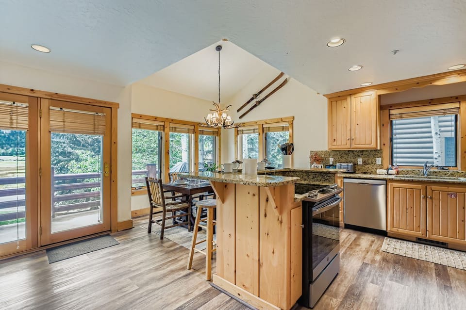 Your open-concept retreat blends rustic charm with modern comfort, featuring warm wood throughout and a stunning antler chandelier.
