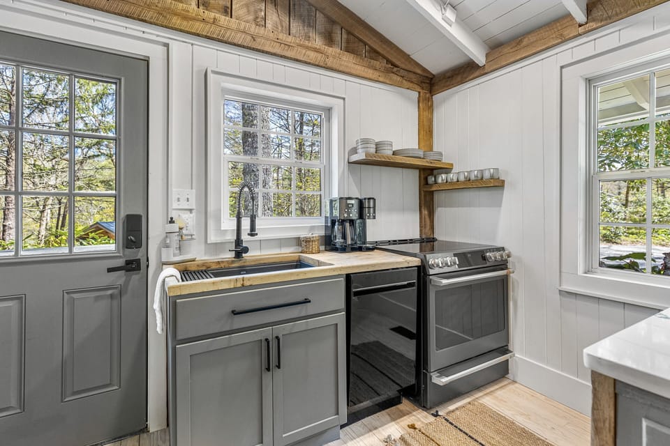 Farmhouse sink, compact dishwasher, oven and stove top.