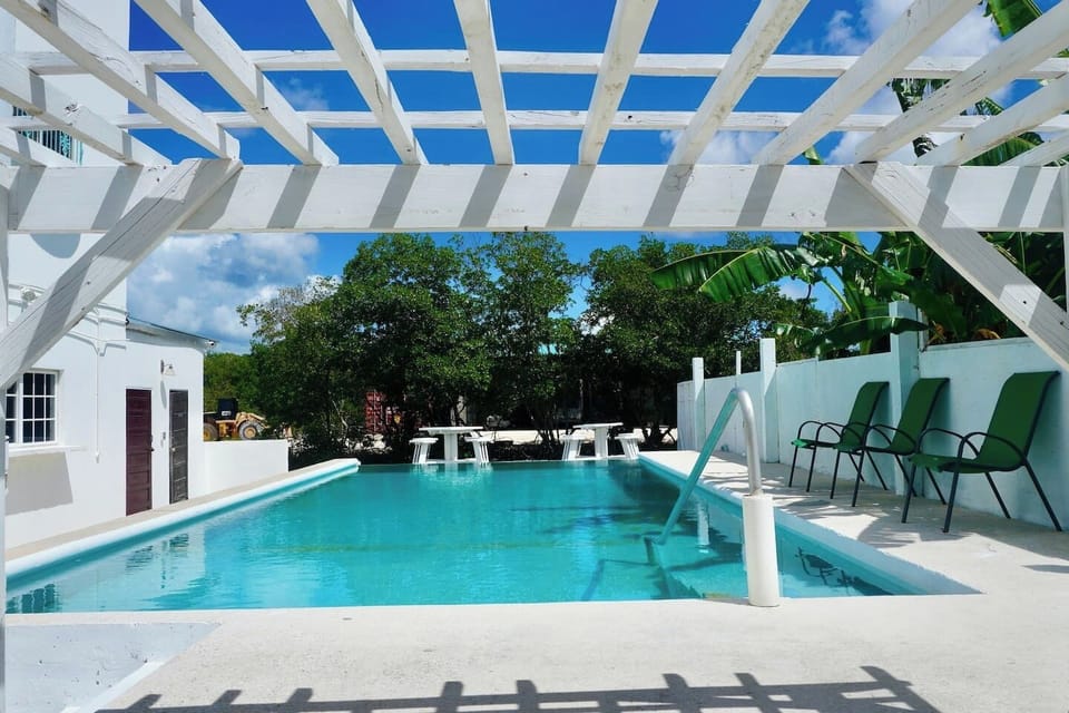 infinity pool with overwater deck, pergola, picnic table,s and chairs