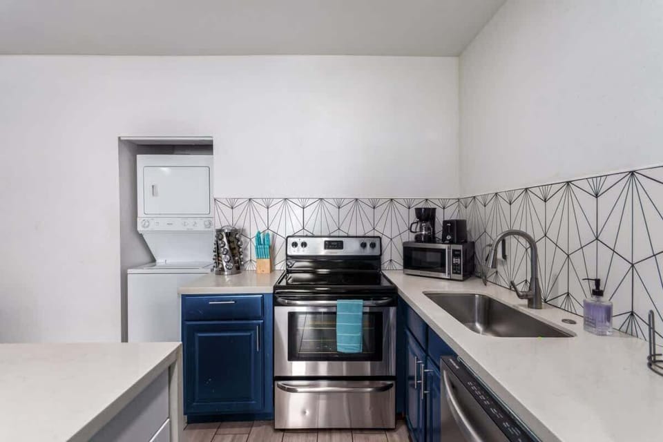 Fully equipped kitchen with sleek cabinetry, a modern backsplash, and all the essentials for cooking during your stay.