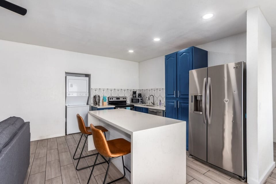 Modern Back Unit: Modern kitchen with a large island, stainless steel appliances, and plenty of seating for group meals.kitchen with a large island, stainless steel appliances, and plenty of seating for group meals.