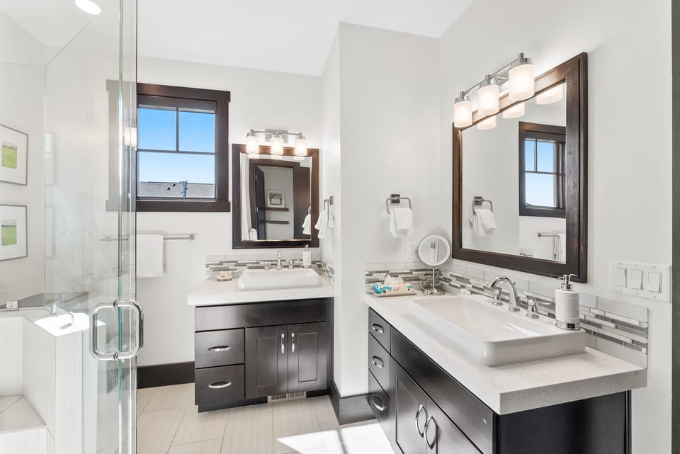 - Refresh in a bathroom with dual sinks and modern vanities  
- Glass shower and bright tile work create a spa-like atmosphere  
- Large mirrors and natural light make mornings easy and bright