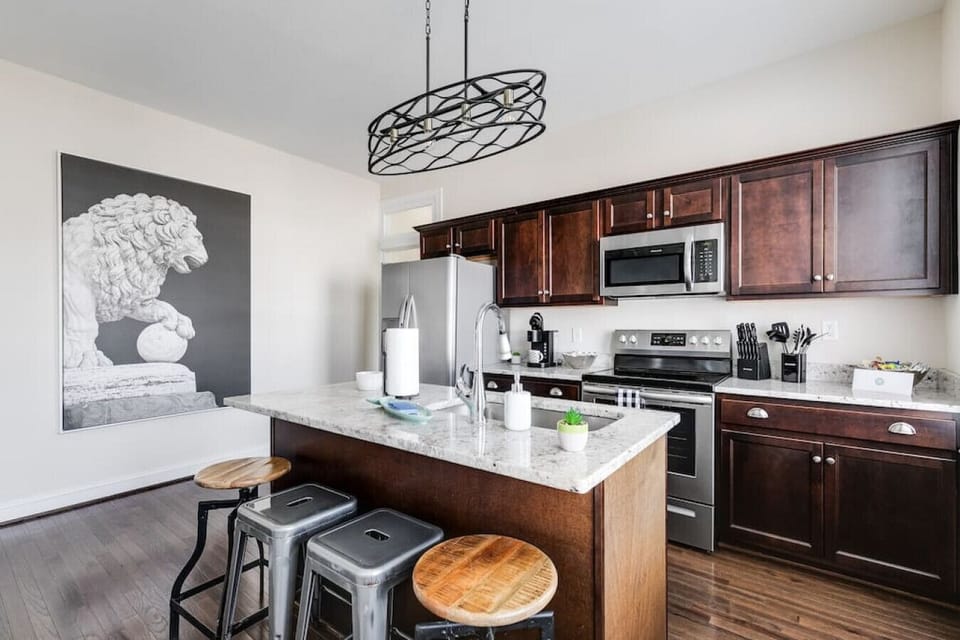 Bright, fully equipped kitchen with island seating for four, a flat‑screen TV for mealtime entertainment, full‑size fridge and freezer, oven, stove, microwave, Keurig, toaster, and all the essentials you need to cook comfortably during your stay.