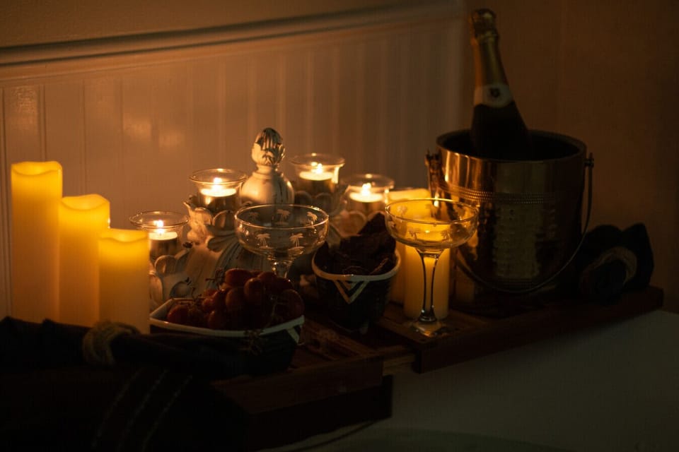 Soft candlelight, fruit, and chilled champagne set the mood for a relaxing evening soak.