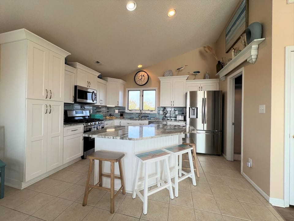 Your fully equipped kitchen features granite countertops, stainless steel appliances, and a convenient island for meal prep and casual dining.
