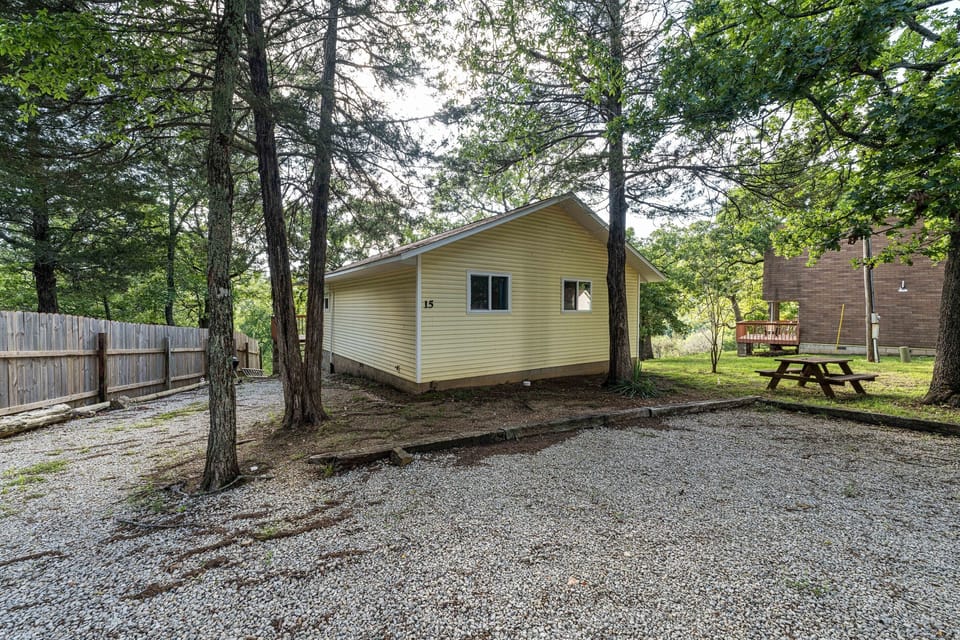 Cabin 15 has a picnic table and a charcoal grill