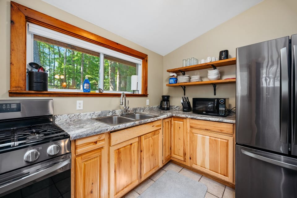 Cook up your favorite meals in a modern, nature-inspired kitchen featuring scenic views and stylish, high-end appliances—where function meets beauty!